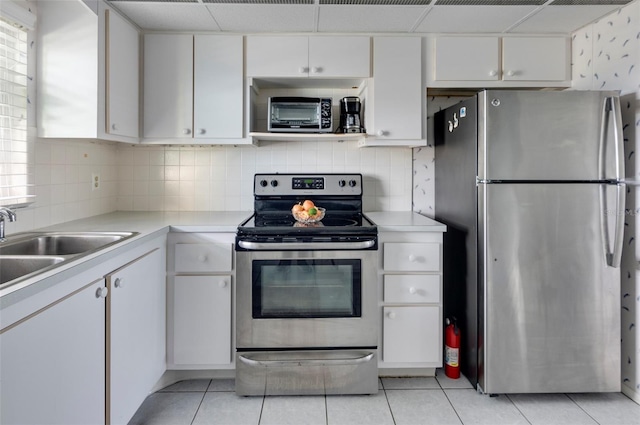 4775 Cove Cir Unit 803, Saint Petersburg, FL 33708 - kitchen with stainless steel appliances, light countertops, light tile patterned floors, and white cabinets