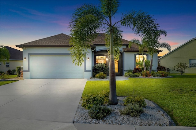 12830 24th Street Cir E, Parrish, FL 34219 - view of front of house with stucco siding, an attached garage, concrete driveway, and a yard
