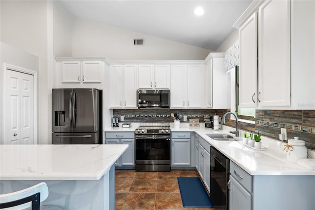 12830 24th Street Cir E, Parrish, FL 34219 - kitchen featuring stainless steel appliances, lofted ceiling, backsplash, and white cabinets
