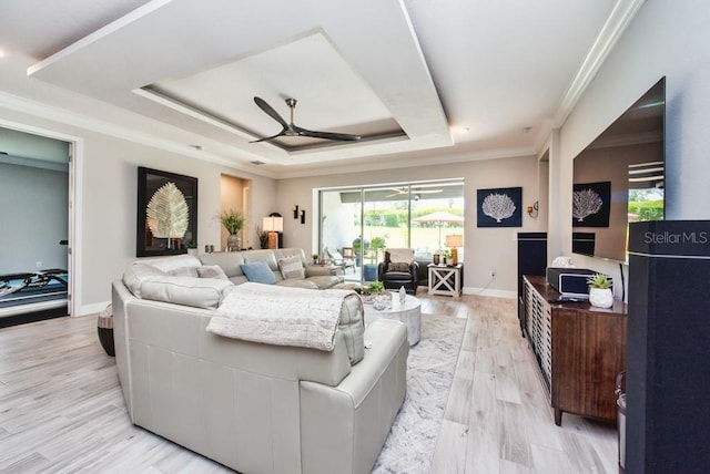 4906 Los Robles Ct, Palmetto, FL 34221 - living area featuring a ceiling fan, a tray ceiling, light wood-style flooring, and crown molding