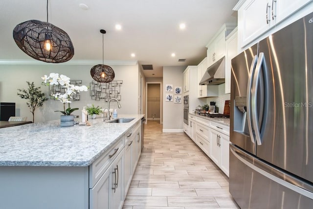 4906 Los Robles Ct, Palmetto, FL 34221 - kitchen with stainless steel appliances, under cabinet range hood, white cabinetry, light stone countertops, and crown molding