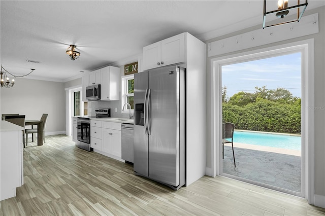 3721 Casaba Loop, Valrico, FL 33596 - kitchen featuring appliances with stainless steel finishes, a chandelier, light countertops, and white cabinetry