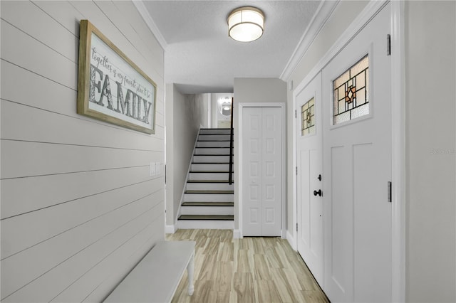 3721 Casaba Loop, Valrico, FL 33596 - foyer entrance with stairs, a textured ceiling, ornamental molding, and light wood finished floors