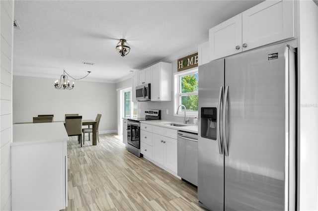 3721 Casaba Loop, Valrico, FL 33596 - kitchen featuring appliances with stainless steel finishes, white cabinets, light countertops, a chandelier, and ornamental molding