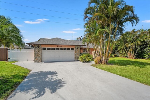2708 W Bird St, Tampa, FL 33614 - view of front facade with driveway, an attached garage, and stone siding