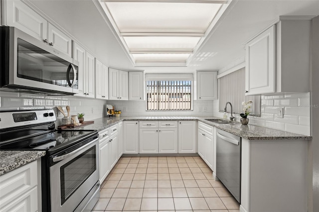 2708 W Bird St, Tampa, FL 33614 - kitchen with appliances with stainless steel finishes, light tile patterned floors, tasteful backsplash, white cabinets, and light stone counters