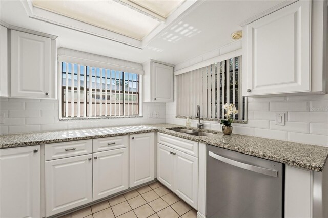 2708 W Bird St, Tampa, FL 33614 - kitchen featuring stainless steel dishwasher, backsplash, white cabinetry, and light stone countertops