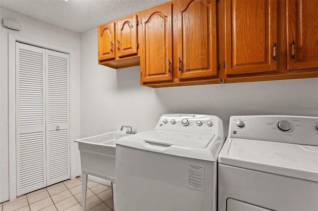 2708 W Bird St, Tampa, FL 33614 - laundry area with independent washer and dryer, light tile patterned floors, cabinet space, and a textured ceiling