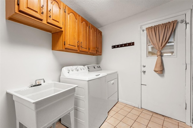 2708 W Bird St, Tampa, FL 33614 - laundry room featuring washing machine and dryer, cabinet space, light tile patterned floors, and a textured ceiling
