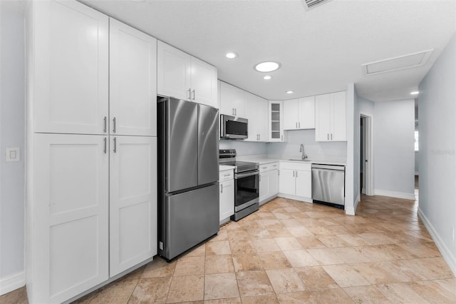 4849 Floramar Ter, New Port Richey, FL 34652 - kitchen featuring appliances with stainless steel finishes, white cabinets, glass insert cabinets, recessed lighting, and light countertops