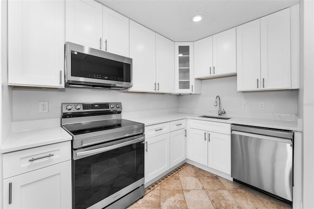 4849 Floramar Ter, New Port Richey, FL 34652 - kitchen with stainless steel appliances, light countertops, white cabinets, recessed lighting, and glass insert cabinets