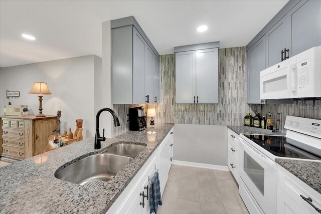 511 Foxglove Cir Unit B, Sun City Center, FL 33573 - kitchen with white appliances, light stone countertops, tasteful backsplash, gray cabinets, and light tile patterned floors
