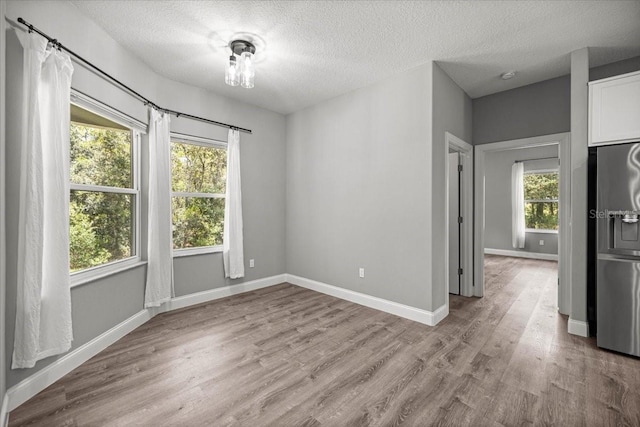 5352 W Corral Pl, Beverly Hills, FL 34465 - empty room with healthy amount of natural light, wood finished floors, a textured ceiling, and a smoke detector