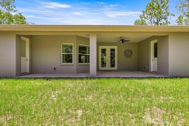 5352 W Corral Pl, Beverly Hills, FL 34465 - doorway to property featuring french doors, stucco siding, a lawn, and ceiling fan