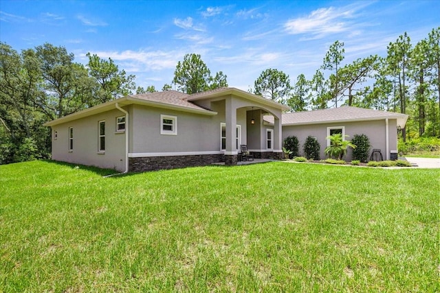 5352 W Corral Pl, Beverly Hills, FL 34465 - view of front of home with stucco siding, a front yard, and stone siding