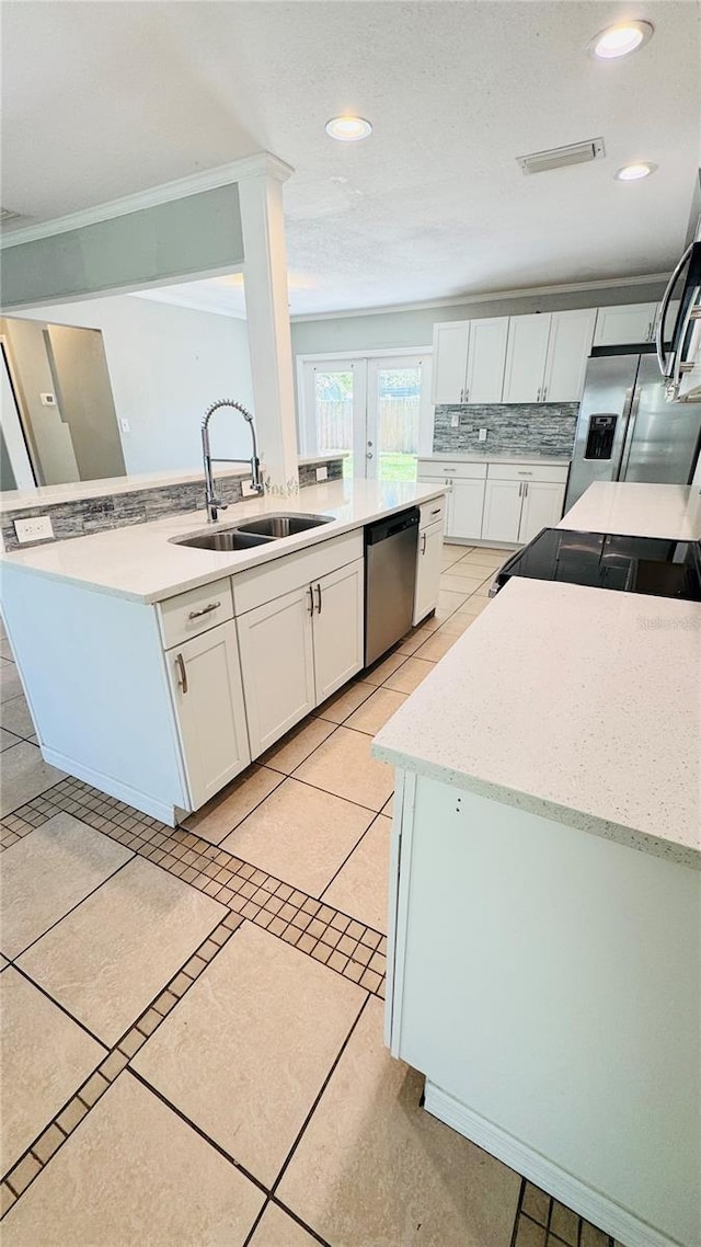 1507 W Le Compte Dr, Tampa, FL 33604 - kitchen with stainless steel appliances, white cabinetry, light tile patterned floors, backsplash, and recessed lighting