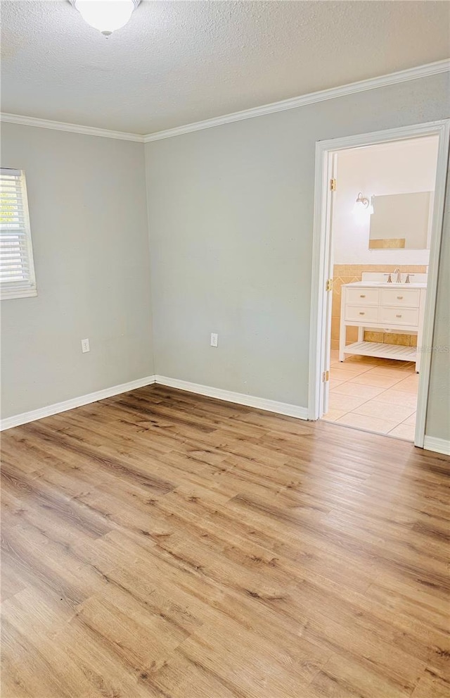 1507 W Le Compte Dr, Tampa, FL 33604 - spare room featuring crown molding, light wood-style floors, and a textured ceiling
