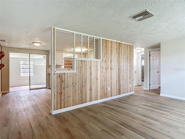 6632 Sierra Ter, New Port Richey, FL 34652 - spare room featuring wood finished floors, a textured ceiling, and wooden walls