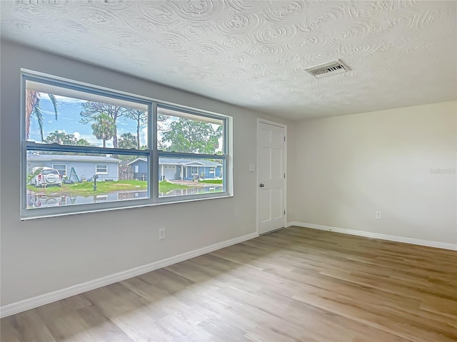 6632 Sierra Ter, New Port Richey, FL 34652 - empty room featuring wood finished floors and a textured ceiling