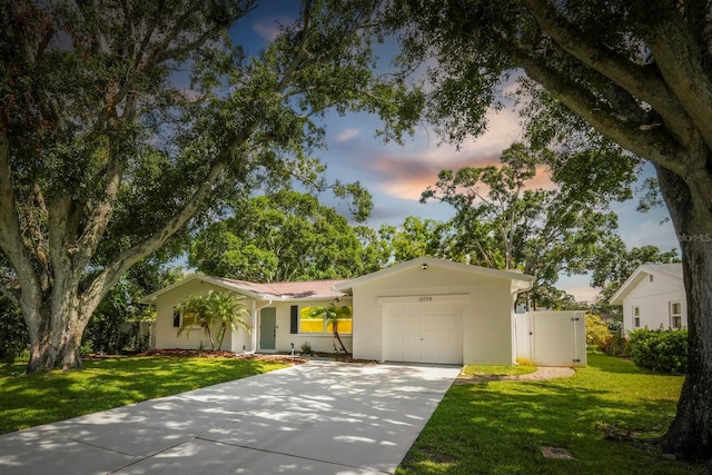 11779 82nd Ter, Seminole, FL 33772 - ranch-style home featuring concrete driveway, an attached garage, a front lawn, and stucco siding