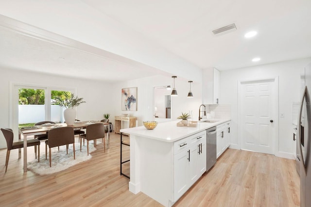 11779 82nd Ter, Seminole, FL 33772 - kitchen with dishwasher, a peninsula, light wood-style floors, white cabinetry, and recessed lighting