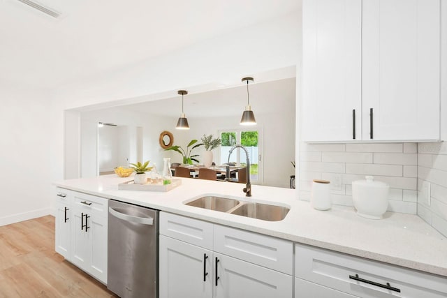 11779 82nd Ter, Seminole, FL 33772 - kitchen featuring dishwasher, tasteful backsplash, white cabinets, hanging light fixtures, and light wood finished floors
