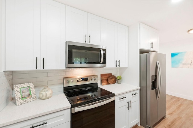11779 82nd Ter, Seminole, FL 33772 - kitchen featuring appliances with stainless steel finishes, white cabinetry, light wood finished floors, and backsplash