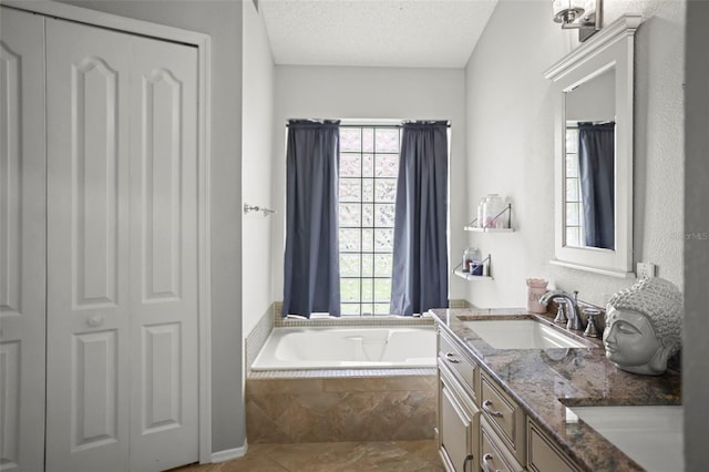 4948 Ridgemoor Cir, Palm Harbor, FL 34685 - full bathroom featuring plenty of natural light, a garden tub, double vanity, a textured ceiling, and a closet