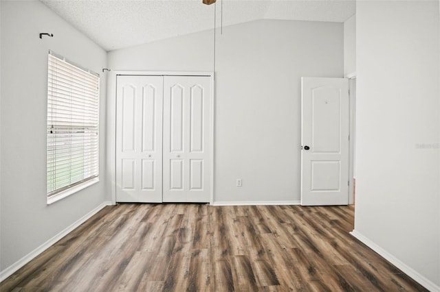 4948 Ridgemoor Cir, Palm Harbor, FL 34685 - unfurnished bedroom featuring vaulted ceiling, wood finished floors, a closet, and a textured ceiling