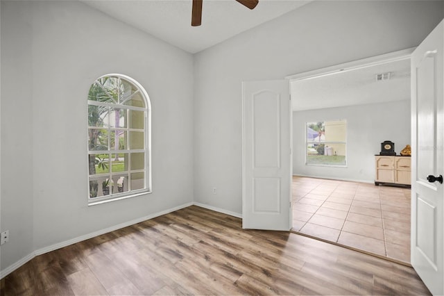 4948 Ridgemoor Cir, Palm Harbor, FL 34685 - unfurnished room featuring healthy amount of natural light, ceiling fan, wood finished floors, and vaulted ceiling