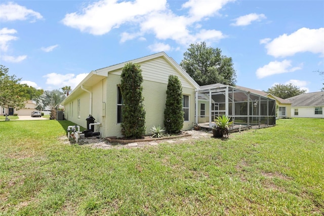 4948 Ridgemoor Cir, Palm Harbor, FL 34685 - view of home's exterior with a lawn, stucco siding, and glass enclosure