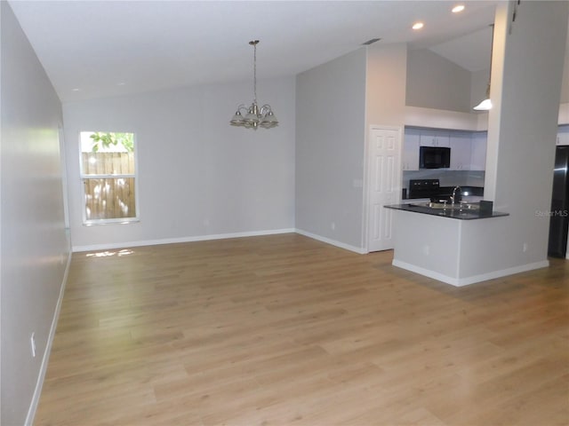 2114 Intervista Ln, Valrico, FL 33594 - unfurnished living room with a chandelier, light wood-type flooring, recessed lighting, and high vaulted ceiling