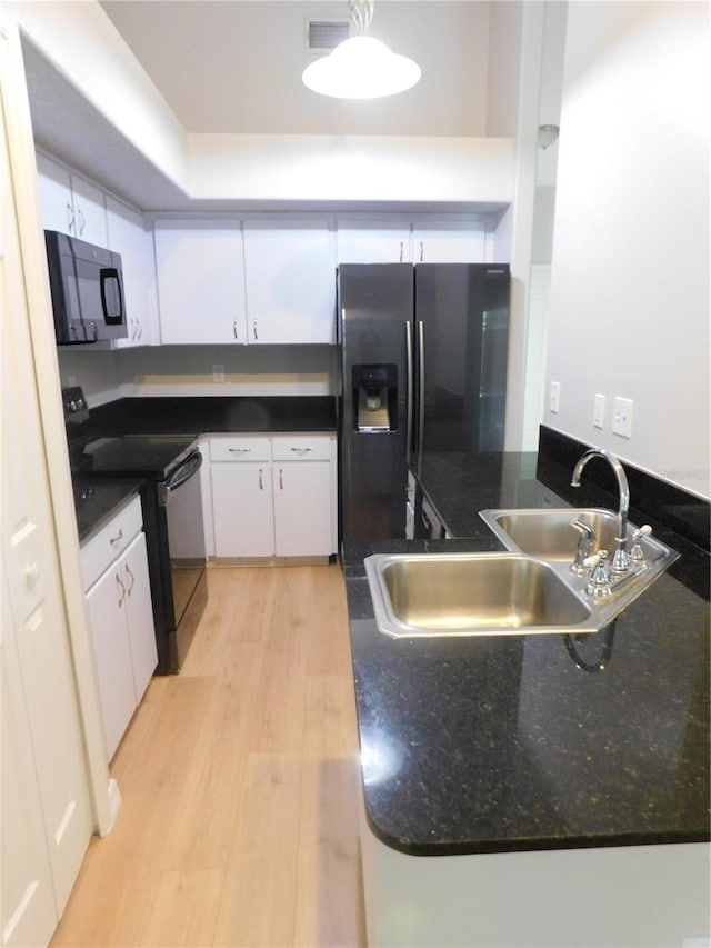 2114 Intervista Ln, Valrico, FL 33594 - kitchen with black appliances, white cabinets, light wood-style floors, and a peninsula