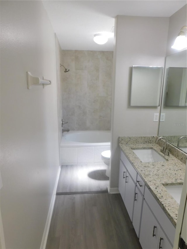 2114 Intervista Ln, Valrico, FL 33594 - bathroom featuring double vanity, wood finished floors, and tiled shower / bath combo
