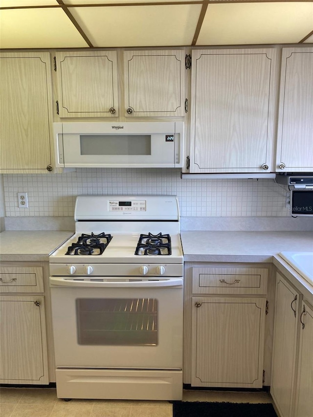 5623 80th St N Unit 314, Saint Petersburg, FL 33709 - kitchen featuring white appliances, light countertops, tasteful backsplash, and tile patterned flooring