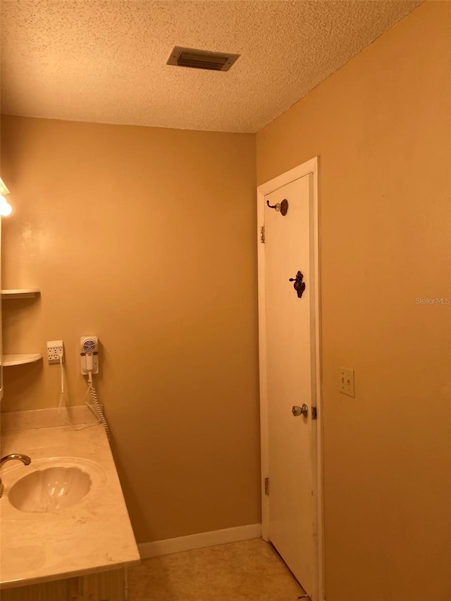 5623 80th St N Unit 314, Saint Petersburg, FL 33709 - bathroom with a textured ceiling, vanity, and tile patterned floors