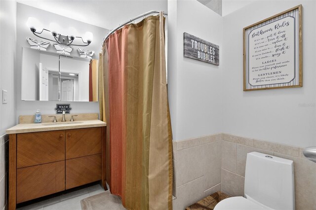 210 Jayview Ave, Lehigh Acres, FL 33936 - bathroom featuring vanity, wainscoting, tile walls, and a shower with shower curtain