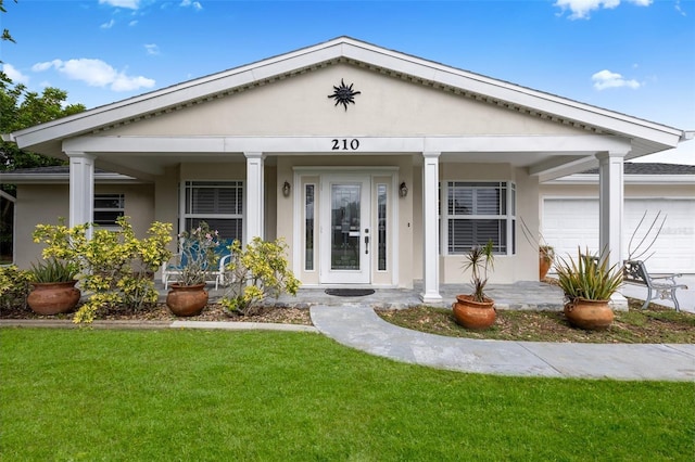 210 Jayview Ave, Lehigh Acres, FL 33936 - view of front facade with a garage, stucco siding, a front yard, and a porch
