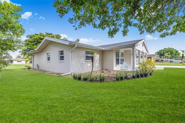 210 Jayview Ave, Lehigh Acres, FL 33936 - view of home's exterior featuring stucco siding and a yard