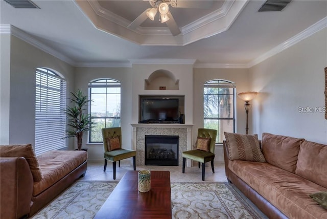 2733 Via Cipriani Unit 830B, Clearwater, FL 33764 - living room with healthy amount of natural light, a ceiling fan, a tile fireplace, light tile patterned flooring, and ornamental molding