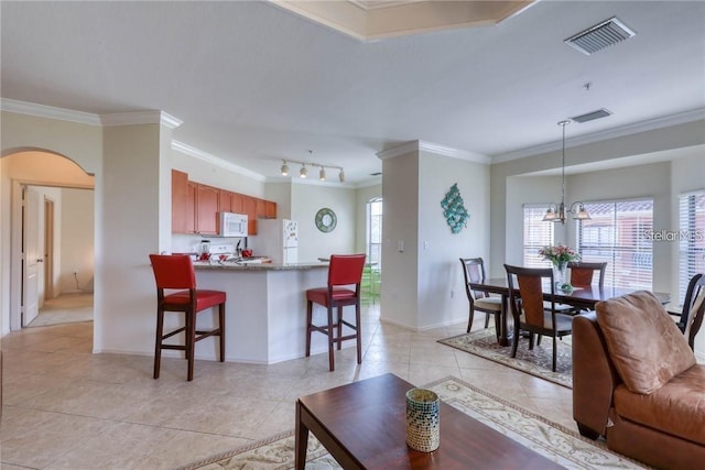 2733 Via Cipriani Unit 830B, Clearwater, FL 33764 - living area featuring crown molding, arched walkways, light tile patterned floors, plenty of natural light, and a chandelier