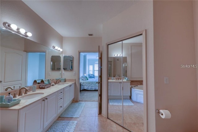 2733 Via Cipriani Unit 830B, Clearwater, FL 33764 - ensuite bathroom featuring double vanity, a garden tub, and tile patterned flooring