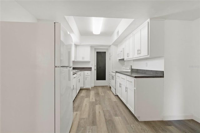 917 Pineview Ave, Clearwater, FL 33756 - kitchen with white appliances, dark countertops, light wood-style floors, and white cabinetry