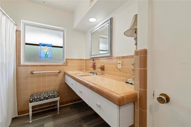 917 Pineview Ave, Clearwater, FL 33756 - bathroom with tile walls, wood finished floors, vanity, a wainscoted wall, and a shower with curtain