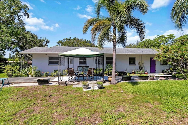 917 Pineview Ave, Clearwater, FL 33756 - rear view of property featuring a lawn, a patio, and stucco siding