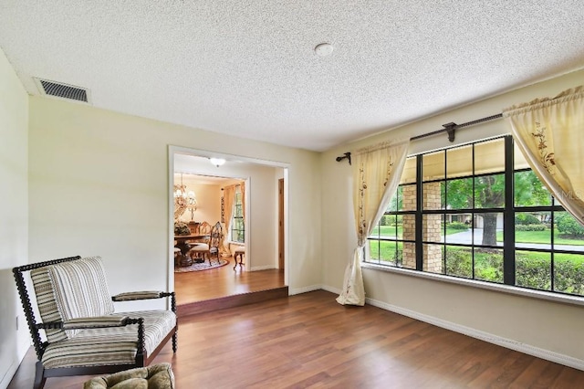 6642 Parson Brown Dr, Orlando, FL 32819 - living area featuring a textured ceiling, wood finished floors, and a chandelier