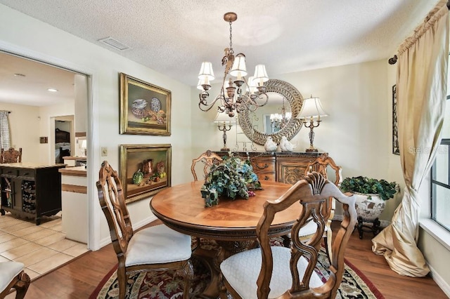 6642 Parson Brown Dr, Orlando, FL 32819 - dining room featuring a chandelier, light wood-type flooring, and a textured ceiling