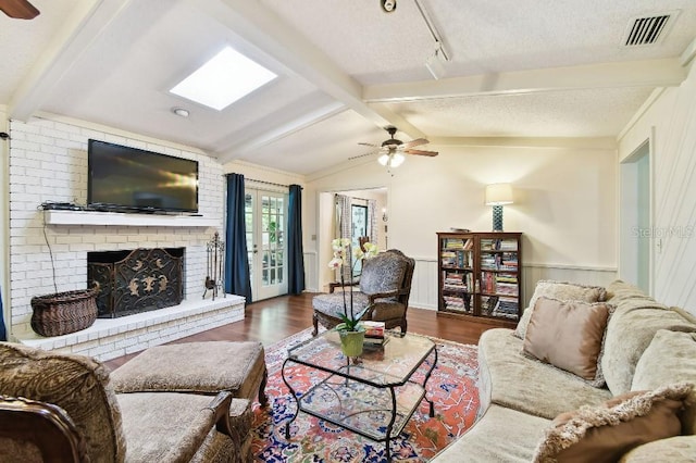 6642 Parson Brown Dr, Orlando, FL 32819 - living area with ceiling fan, dark wood-style floors, a fireplace, a textured ceiling, and a wainscoted wall