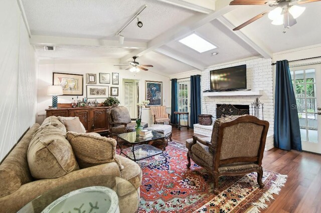 6642 Parson Brown Dr, Orlando, FL 32819 - living room with ceiling fan, wood finished floors, a fireplace, track lighting, and a textured ceiling