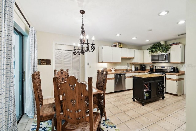 6642 Parson Brown Dr, Orlando, FL 32819 - kitchen featuring stainless steel appliances, a chandelier, white cabinetry, light tile patterned floors, and recessed lighting